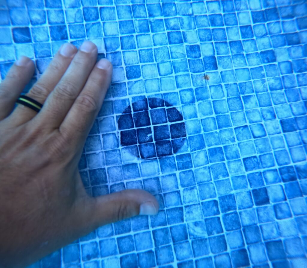 Close-up of a vinyl liner after repair showing a patch securely applied over the previously leaking area.